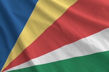 Seychelles flag depicted on folded wavy fabric of old cloth close up