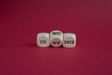 Competence and Confidence symbol. Turned a wooden cube with words Confidence and Competence. Beautiful pink background. Business concept. Copy space