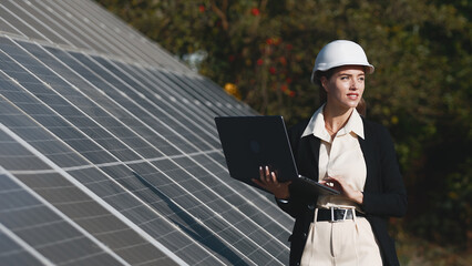 Solar panels and investor with laptop. Business woman with laptop near solar panels. Green energy for home and business