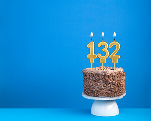 Birthday celebration with candle 132 - Chocolate cake on blue background