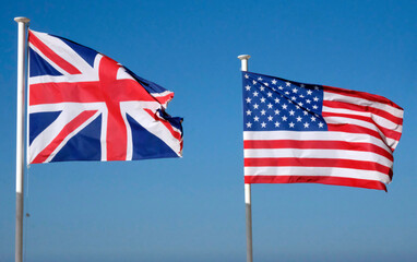 Stars and Stripes and Union Jack - US and UK national flags against the blue sky