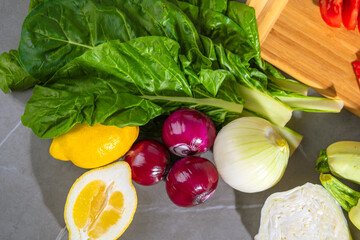 Vegetables on table with cutting board in background