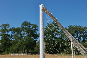 Part of a football goal with trees and concrete spectator seats in the background. The concept for amateur football or local competitions. © Юрій Борисов