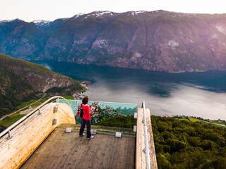 Tourist enjoying fjord view on Stegastein viewpoint Norway