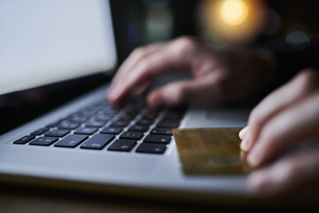 Hacker, laptop and credit card fraud for hacking, cloning and identity theft with person typing at...