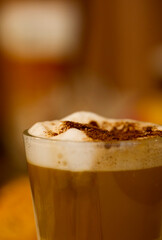 Close-up of a glass with frothy cappuccino and chocolate