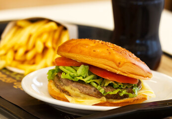 Hamburger with cereal bun, tomato, lettuce and cheese