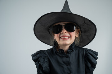 Portrait of a little Caucasian girl in a witch costume on a white background. 