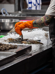 Person Arranging Fresh Seafood on Ice at a Market