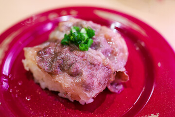Top view of Japanese fresh beef sushi with Japanese rice in red plate, focus selective
