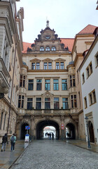 Exploring dresden's historic architecture on a sunny day, tourists wander charming cobblestone streets admiring old buildings and intricate archways