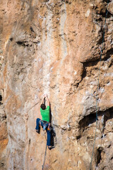 A rock climber climbs to the top along a difficult route.
