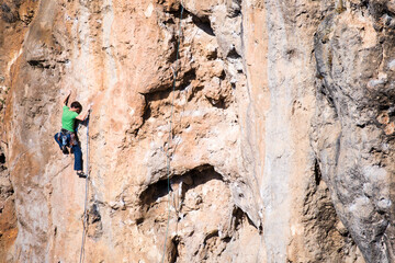 A rock climber climbs to the top along a difficult route.
