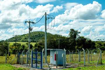 work of a medium voltage transformer with poles, wires, enclosure and its cabin