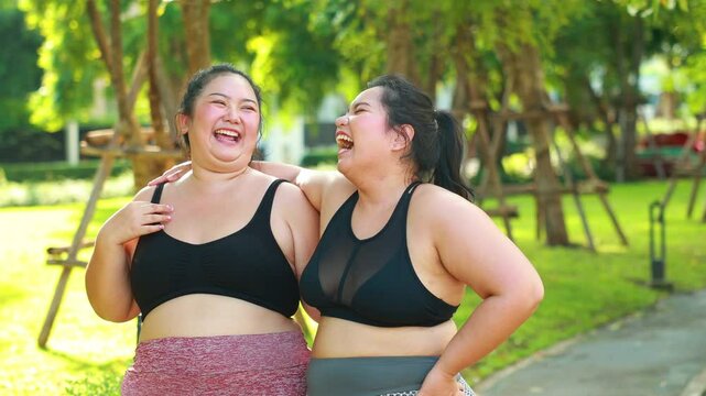 LGBTQ couple exercising outdoor in park. beautiful young chubby overweight woman in sportswear doing exercise outdoors at park. fitness sport club, body and health care. Activity