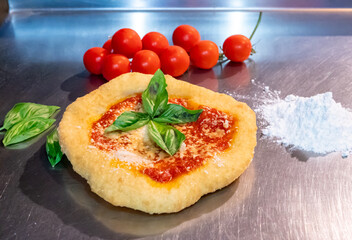 Neapolitan fried pizza with tomato sauce cheese and basil leaves, called Montanara