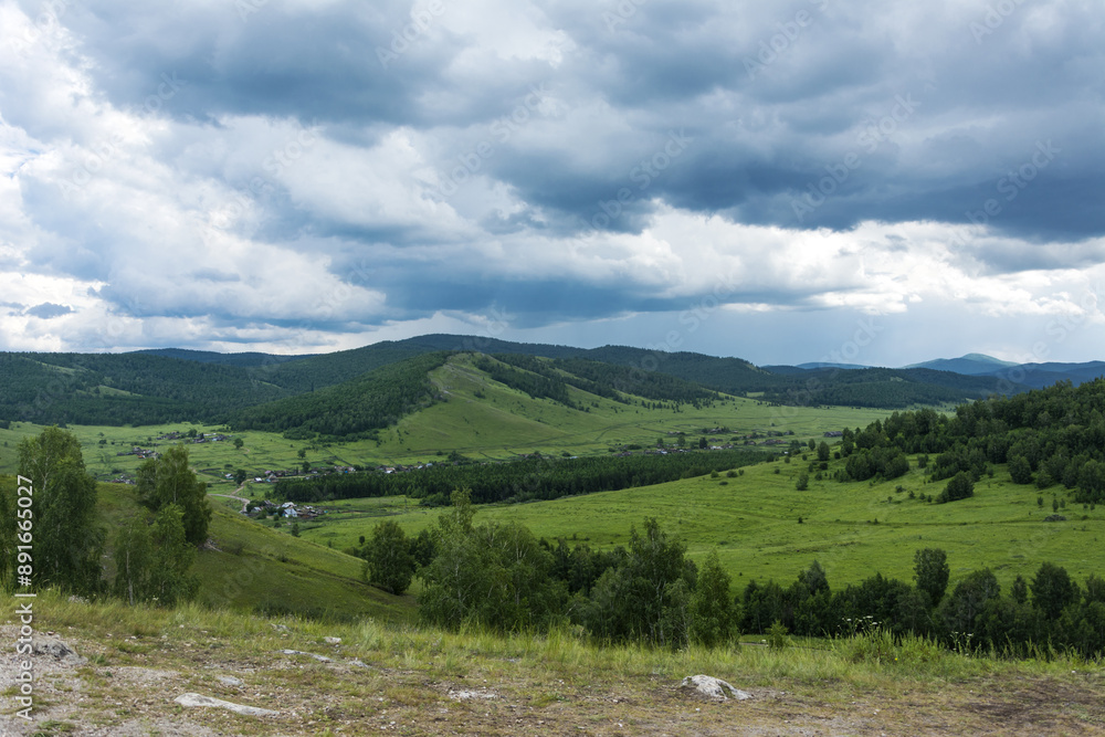 Wall mural a postcard with a view of a bright valley framed by green hills