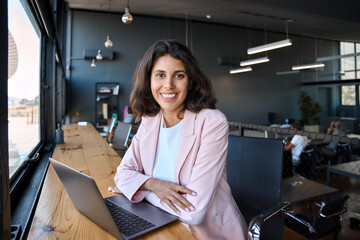 Portrait 30s latin hispanic business woman manager working on laptop computer in modern office....
