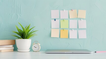 A desk with a laptop, a clock, a potted plant