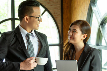 Executive business managers office team working using 
computer drinking hot coffee. Two mid aged colleagues company board after discussing digital strategy at modern meeting room. Copy space.