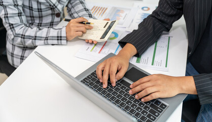 Business People discussion at Table using variety of electronic Devices on grey Office Table Computer, Tablet, printed Paper Charts