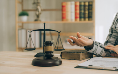 Lawyer working with client discussing contract papers with brass scale about legal legislation