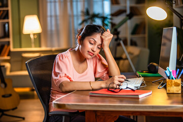 Indian asian  young student or businesswoman using laptop with coffee, books, smartphone, headphone