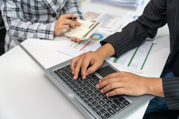 Fototapeta premium Business, technology and office concept - business team with laptop, tablet pc computer and papers having discussion in modern office.