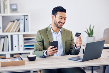 Office, smile and man with credit card by phone for online banking, payment and information. Happy, trader and fintech with laptop at desk for economy investment, transaction or stock market purchase