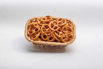 Basket full of pretzels isolated on white background. Golden brown pretzels stacked in a basket.