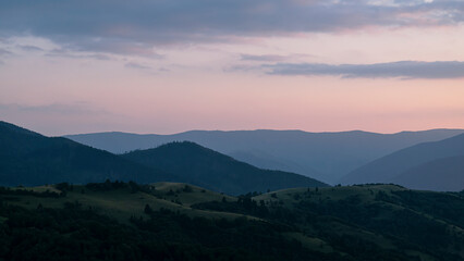 Orange sunset with the setting sun behind the mountains