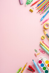 Top vertical view of various colorful school stationery on a pink background, perfect for back to school themes