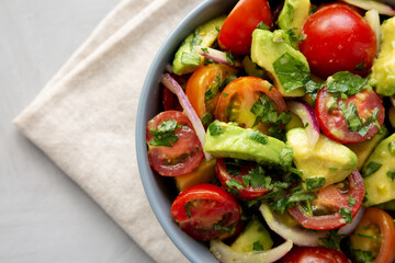 Homemade Avocado And Tomato Salad in a Bowl, top view. Copy space.