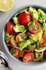 Homemade Avocado And Tomato Salad in a Bowl, top view. Flat lay, overhead, from above.