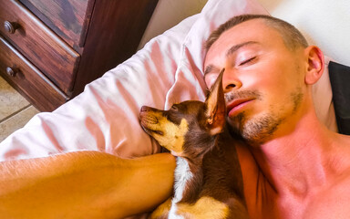 Happy man sleeping with dog in his arm in Mexico.