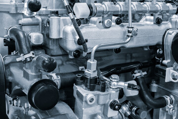 A close up of a car diesel engine with many parts. The engine is made of metal and has a lot of parts