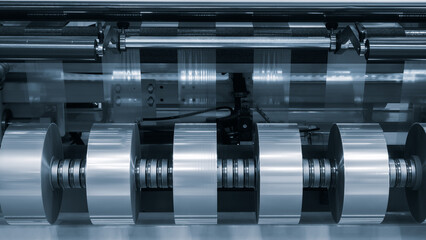 Automatic polyethylene plastic bag production machine with lighting effect. Close-up of the roller of the plastic bag production machine in the light blue scene. product packaging concept