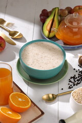 Oatmeal, healthy food item  arranged on wooden background in a ceramic bowl.