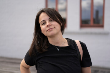 Beautiful girl in a black T-shirt against the backdrop of a city landscape.