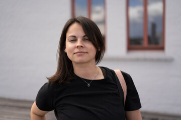 Beautiful girl in a black T-shirt against the backdrop of a city landscape.