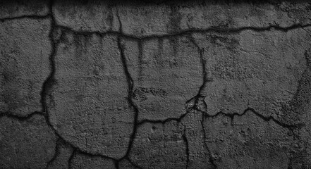 A black and white photo of a wall with cracks and holes. The wall appears to be old and worn down