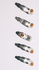 line of tiny glass jars on the sun light on white background