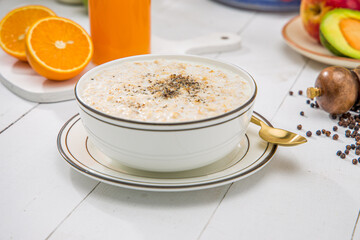 Oatmeal, healthy food item  arranged on wooden background in a ceramic bowl.