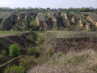 ravines in green grass against the blue sky