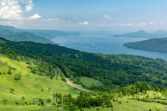 landscape with highway passing around lake and mountains