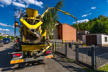 A concrete mixer feeds concrete into the screed when building a house