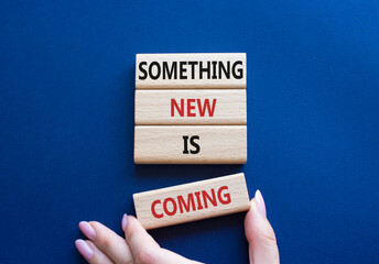 Smth New is coming symbol. Wooden blocks with words Something New is coming. Beautiful deep blue background. Businessman hand. Business and Something New is coming concept. Copy space.