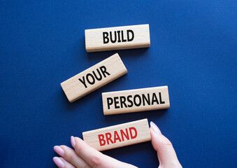 Build your personal Brand symbol. Concept words Build your personal Brand on wooden blocks. Businessman hand. Beautiful deep blue background. Business and Build your personal Brand concept. Copy space