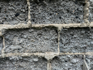 A fragment of a wall made of crumbling cement and slag blocks as a background