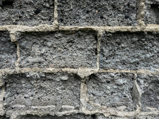 A fragment of a wall made of crumbling cement and slag blocks as a background
